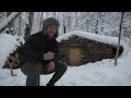 hiding in  cozy dugout during a snow storm , overnight stay in bushcraft shelter