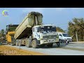 Road Building In Progress Dump Trucks Gravel, Stand Ready to Unload With Asphalt Paver Dominating