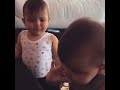 Cute twins pacifier passing