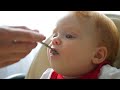 baby eating puree with spoon close up of infant baby face