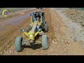 A heavy machinery operator working on a construction site, using a large yellow Grader to move dirt