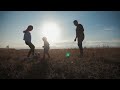 father and two children playing in the field with soccer ball concept of sport