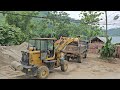 truck carries construction materials, excavator  load goods onto truck.