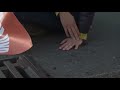Environmental protester glues hand to pavement then throws the glue container in the sewer