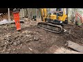 Hammering a drainage trench behind a house