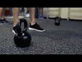 feet of unrecognizable people and kettlebells on the floor in gym  D